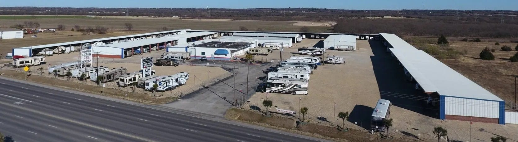 Aerial photograph of the Texas RV Center yard showing rows of covered and open-air RV spaces.